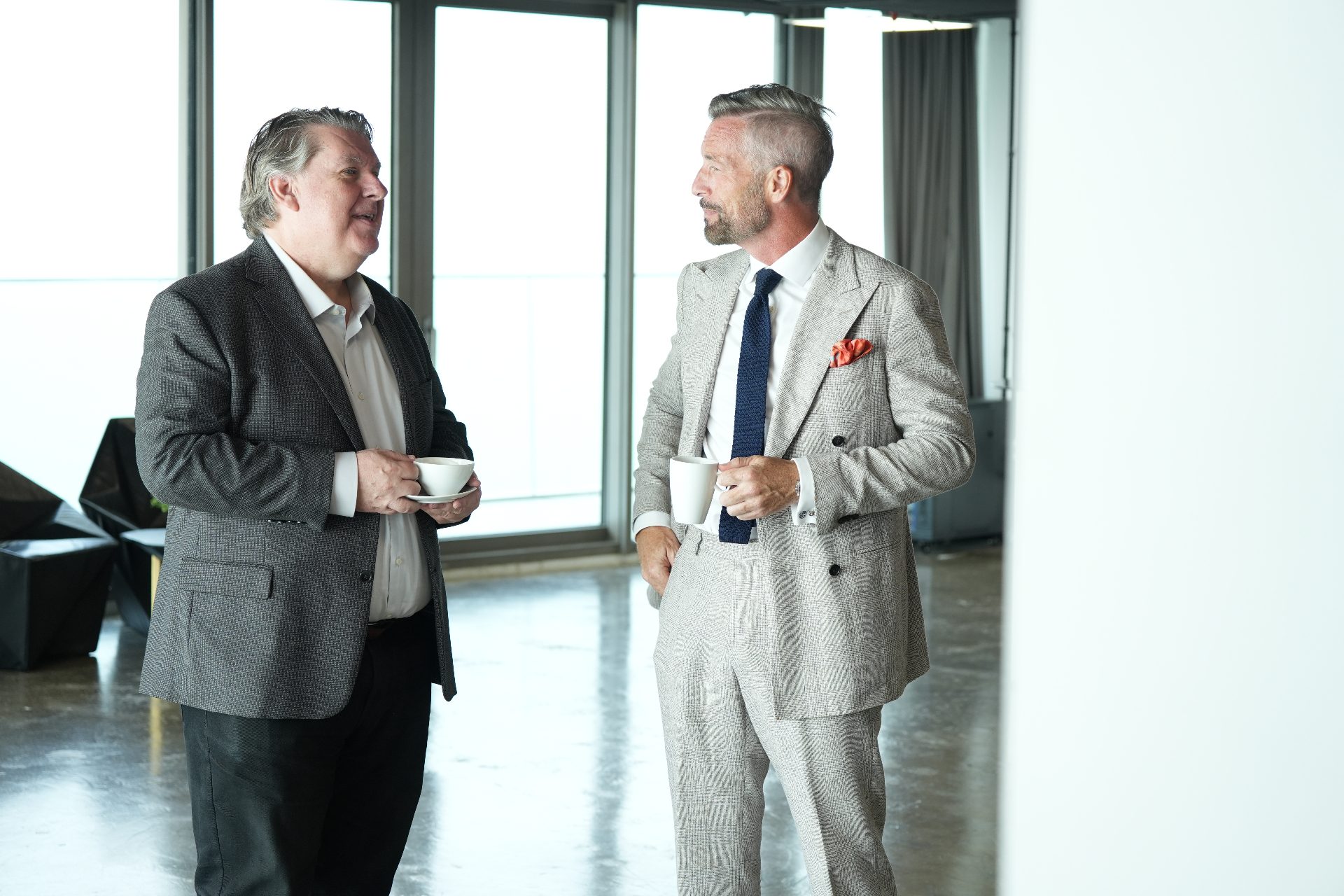 Two attendees in conversation over coffee